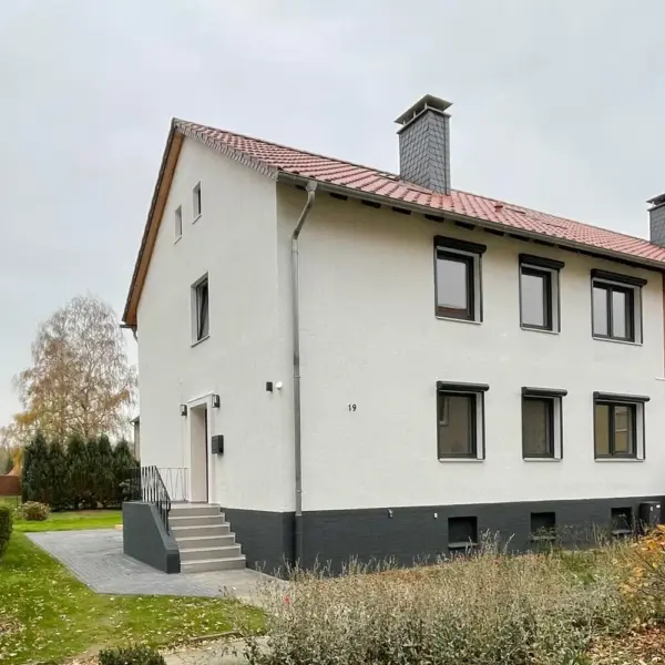 Gesamtansicht Wohnhaus nach energetischer Vollsanierung – neue Fenster, Fassade und Sockel, Artiscon Beratung GmbH