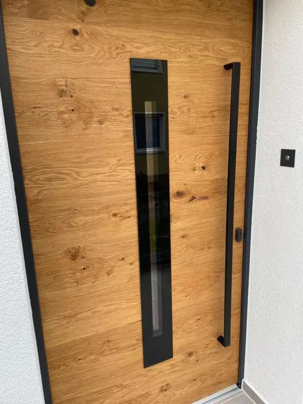 Neue Holzhaustür mit Glasstreifen und schwarzem Griff – Detail nach energetischer Sanierung durch Artiscon